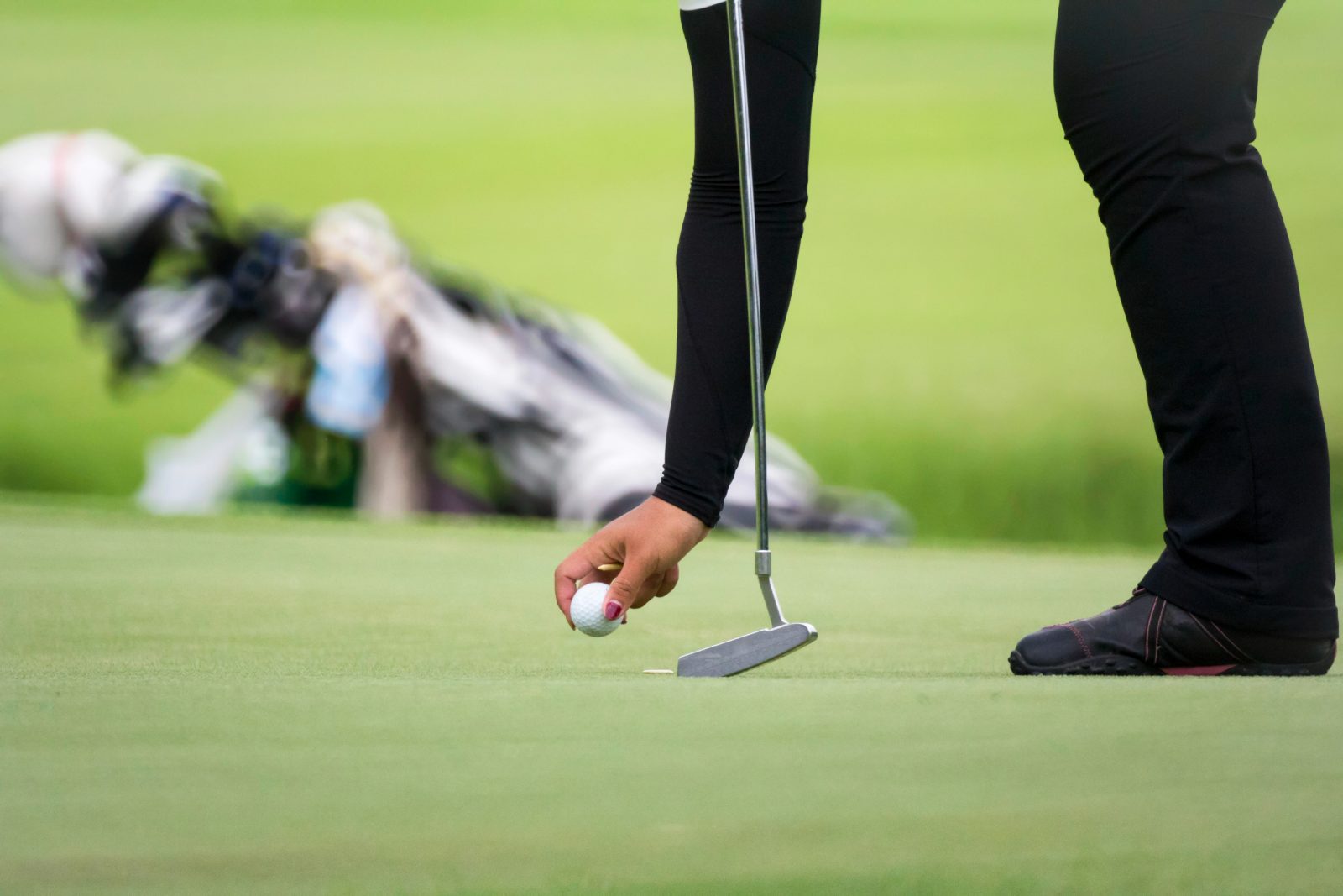 A player places a ball on the putting green
